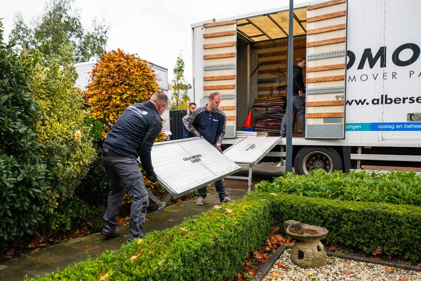 Albers verhuizer draagt een beschermd meubel zorgvuldig naar de verhuiswagen