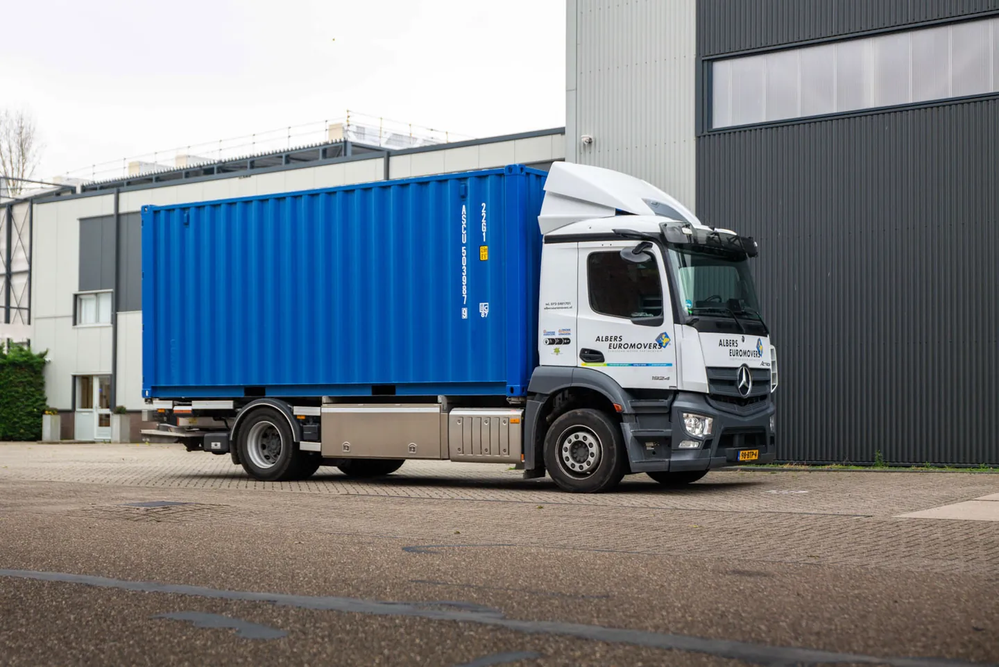 Albers containerwagen met blauwe 20 ft container bij de opslaglocatie